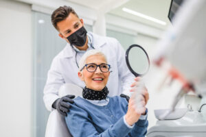 Patient Being Shown Her Smile After Getting Dental Implants