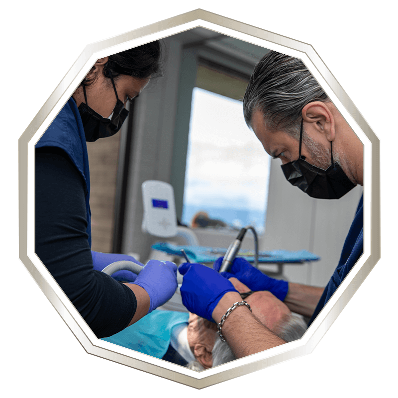 doctor and dental assistant in the middle of dental implant procedure