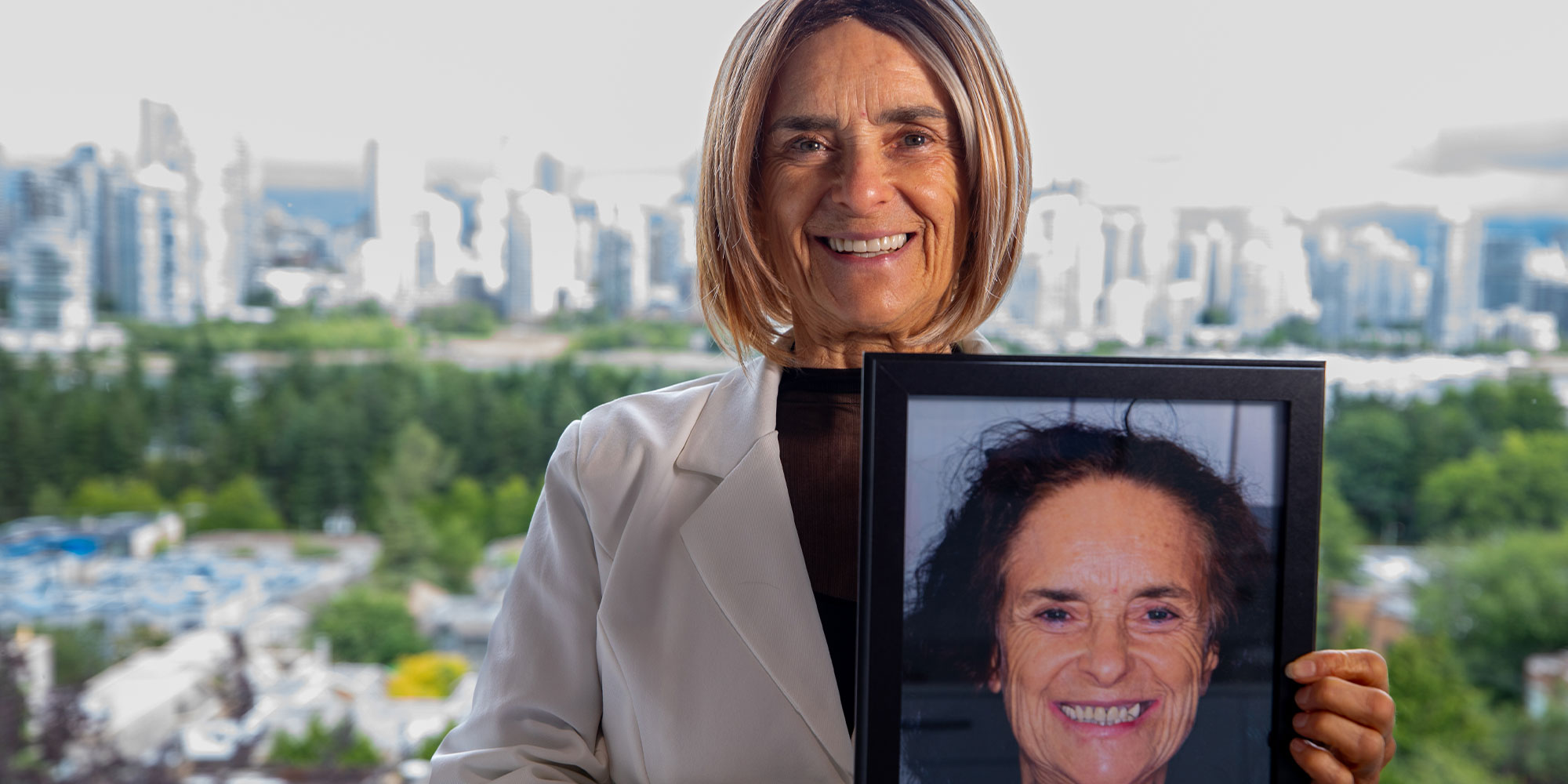 Patient smiling holding up a before photo of her teeth before dental procedure