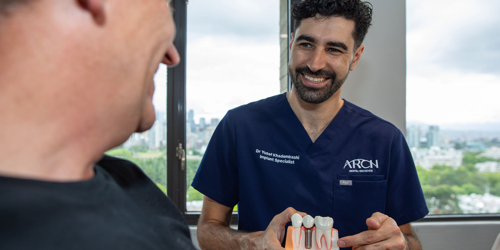 doctor pointing to model of dental implants