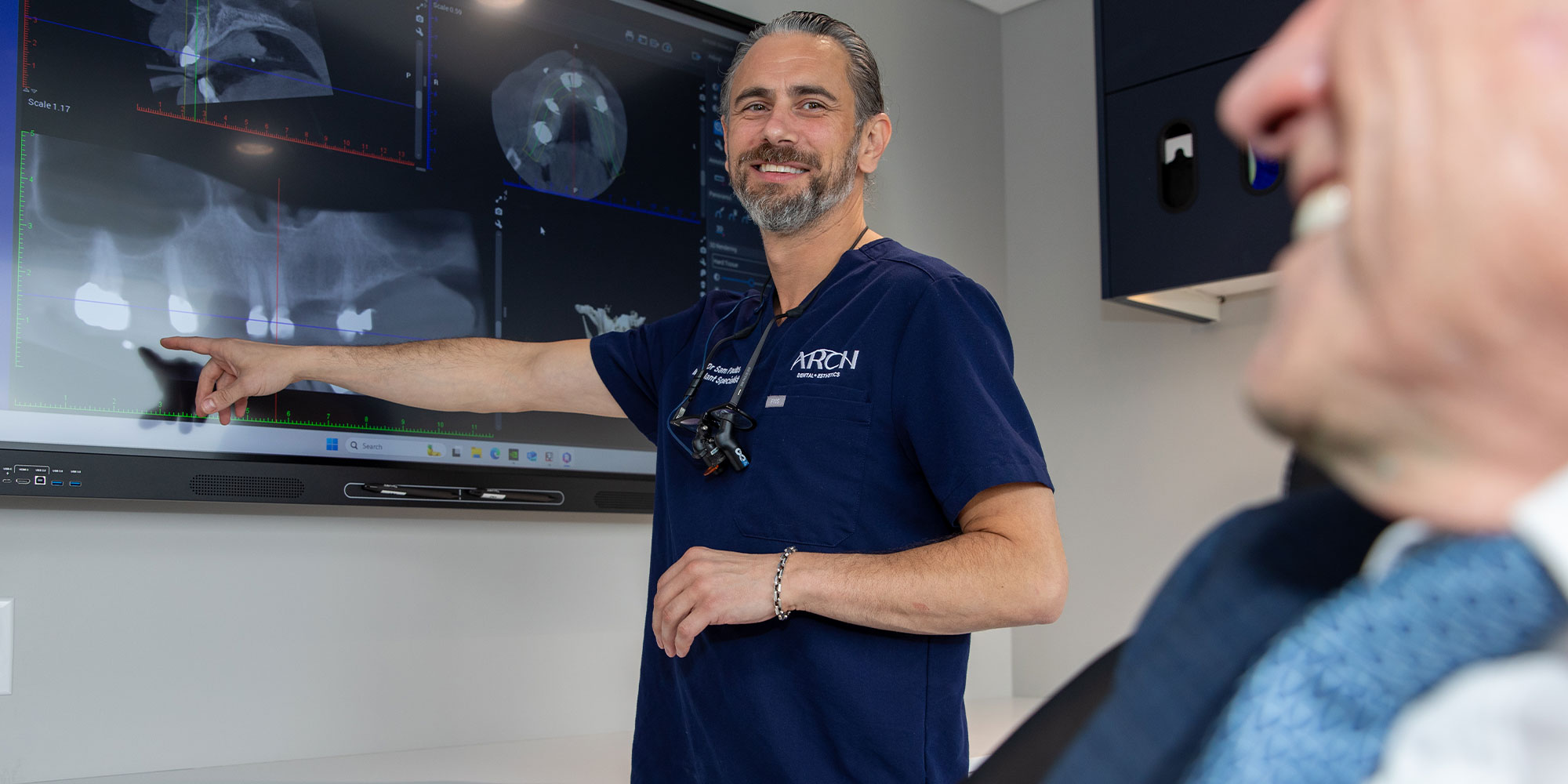 Doctor pointing at dental x-ray consulting with Patient